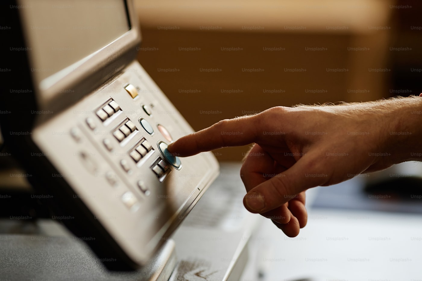 Hand pressing the start button on a professional printing machine